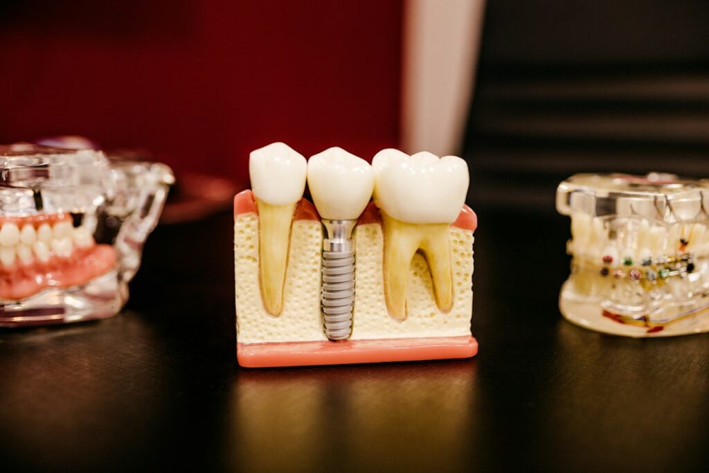 Adult patient receiving a dental implant examination while a dentist checks the gumline and restoration.